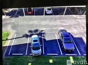 Bradenton condo for rent - A parking lot with a white car and a blue car parked in the spaces.