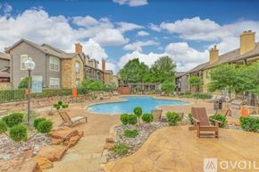 Plano apartment for rent - A swimming pool surrounded by a patio with chairs and a fence.