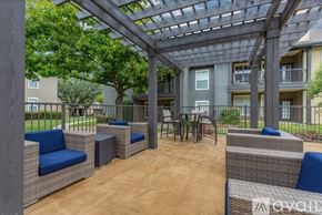 Plano apartment for rent - A patio with a pergola and wicker furniture.
