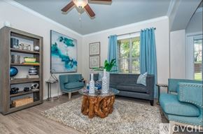 Plano apartment for rent - A living room with a grey couch, a wooden coffee table, and a blue chair.