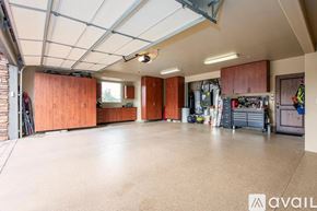 Sedona house for rent - A spacious garage with wooden cabinets and a variety of tools.