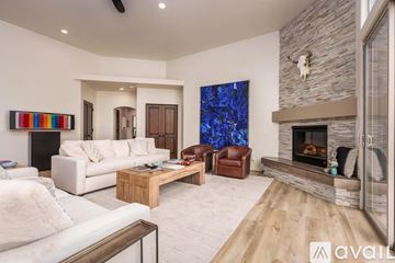 Sedona house for rent - A modern living room with a fireplace and a large painting on the wall.