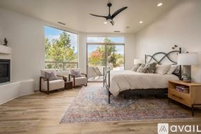 Sedona house for rent - A bedroom with a large bed and a fireplace.