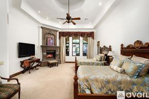 Scottsdale house for rent - A bedroom with a large bed and a fireplace.