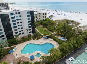 Siesta Key condo for rent - An aerial view of a hotel with a swimming pool and beachfront location.