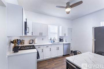 St. Louis house for rent - A kitchen with white cabinets and a marble table.