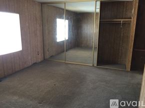 Hemet house for rent - A room with a sliding glass door and wooden walls.