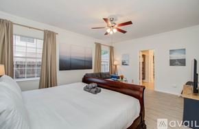 Cypress house for rent - A bedroom with a large bed and a ceiling fan.
