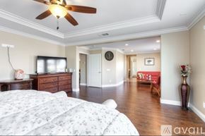 Corona apartment for rent - A bedroom with a large bed and a ceiling fan.