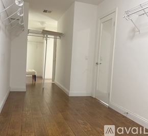 Corona apartment for rent - A room with a wooden floor and white walls.