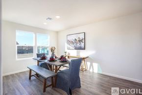 Bullhead City house for rent - A dining room with a table set for two and a painting of camels on the wall.