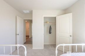 Bullhead City house for rent - A white bedroom with a bed on the left and a wardrobe on the right.