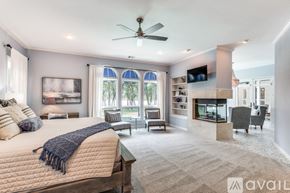 Lakewood Village house for rent - A bedroom with a large bed and a ceiling fan.