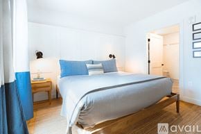 New Castle apartment for rent - A bedroom with a large bed and a nightstand with a lamp.