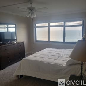 Fort Pierce condo for rent - A bedroom with a large bed, a dresser, and a television.