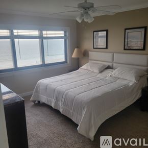 Fort Pierce condo for rent - A bedroom with a large bed and a ceiling fan.