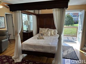 Gordonsville apartment for rent - A bedroom with a canopy bed and a view of a backyard.