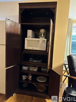 Gordonsville apartment for rent - A microwave oven is sitting on a shelf in a kitchen cabinet.