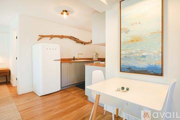 New Castle apartment for rent - A kitchen with a white table and chairs and a painting on the wall.