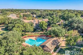 Irving apartment for rent - An aerial view of a house with a swimming pool surrounded by trees.