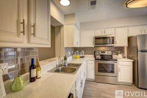 Irving apartment for rent - A kitchen with white cabinets and a stainless steel refrigerator.