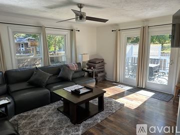 Newburgh apartment for rent - A living room with a black leather couch and a wooden coffee table.