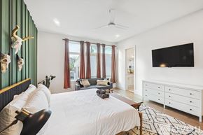 Dallas townhouse for rent - A bedroom with a white bed and a black and white rug.