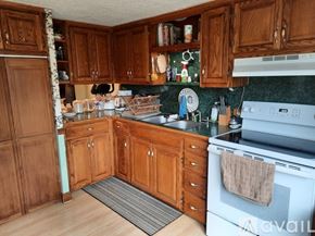 Warrensville house for rent - A kitchen with wooden cabinets and a white oven.