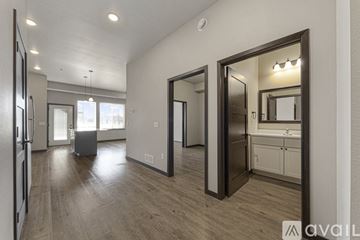 Mankato apartment for rent - A spacious kitchen with a refrigerator, sink, and cabinets is visible through a large mirror.