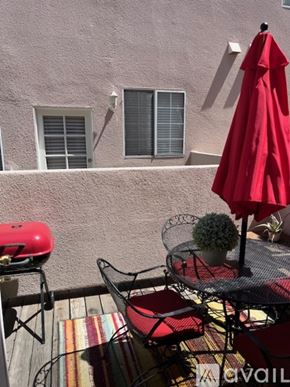 Inglewood condo for rent - A red umbrella is on a table outside a building.