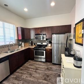 Inglewood condo for rent - A kitchen with brown cabinets and a stainless steel refrigerator.