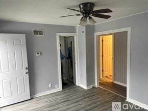 Rockford apartment for rent - A room with a ceiling fan and a person standing in the doorway.