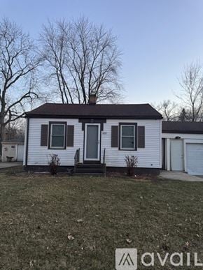 Rockford apartment for rent - A small white house with a black door and a chimney.