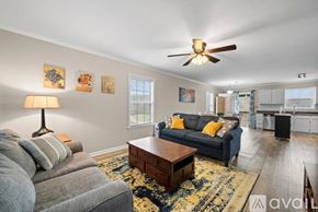Winston-Salem apartment for rent - A living room with a grey couch, a coffee table, and a ceiling fan.