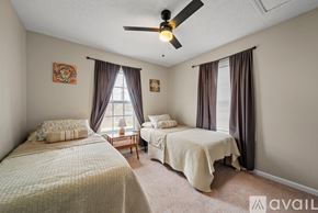 Winston-Salem apartment for rent - A bedroom with two beds and a ceiling fan.