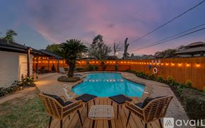 Houston house for rent - A pool surrounded by chairs and string lights.