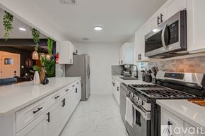 Houston house for rent - A kitchen with white cabinets and a black stove top oven.