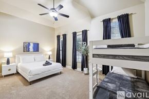 Rowlett house for rent - A bedroom with a white bed and a bunk bed with a ceiling fan.