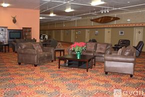 Crivitz apartment for rent - A living room with a brown leather couch, a coffee table, and a vase of flowers.