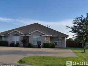 College Station townhouse for rent - A house with a brown roof and a driveway in front.