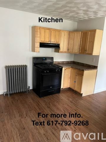 Boston apartment for rent - A kitchen with wooden cabinets and a black stove top oven.