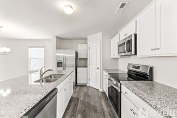Vass house for rent - A kitchen with white cabinets and granite countertops.