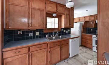 Cleveland Heights house for rent - A kitchen with wooden cabinets and a white dishwasher.