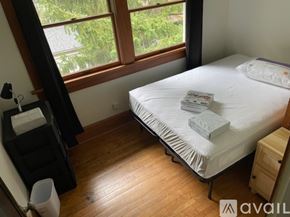 Cleveland Heights house for rent - A bedroom with a bed, nightstand, and window.