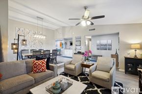 Garland house for rent - A living room with a grey couch, a coffee table, and a ceiling fan.