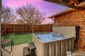 Garland house for rent - A hot tub is on a patio with a table and chairs.