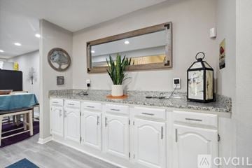 Garland house for rent - A kitchen with white cabinets and a large mirror above the counter.