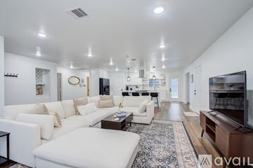Houston house for rent - A spacious living room with white furniture and a rug.