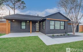 Houston house for rent - A modern house with a dark grey exterior and a large front yard.