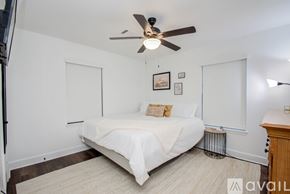 Houston house for rent - A bedroom with a white bed and a ceiling fan.